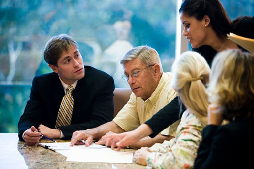 Couple with loan officer at home closing