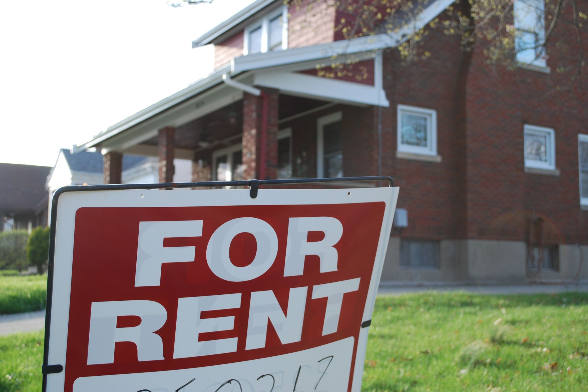 For Rent sign in front of brick home