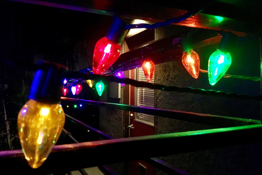 Close up of multi-colored Christmas lights on railing