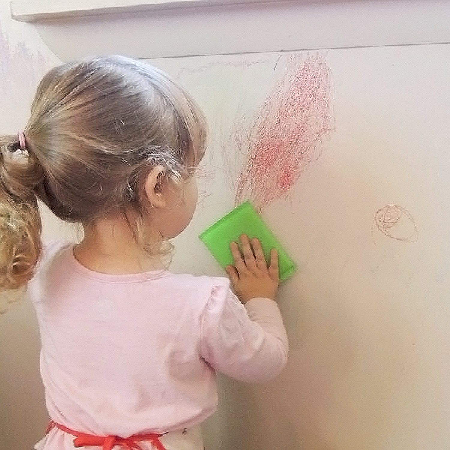 A child writing on a wall with crayon