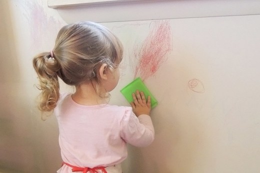 A child writing on a wall with crayon