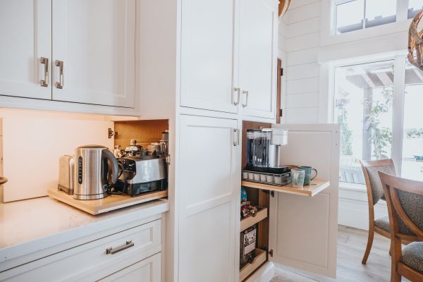 White kitchen with cabinet open to reveal hidden pull out