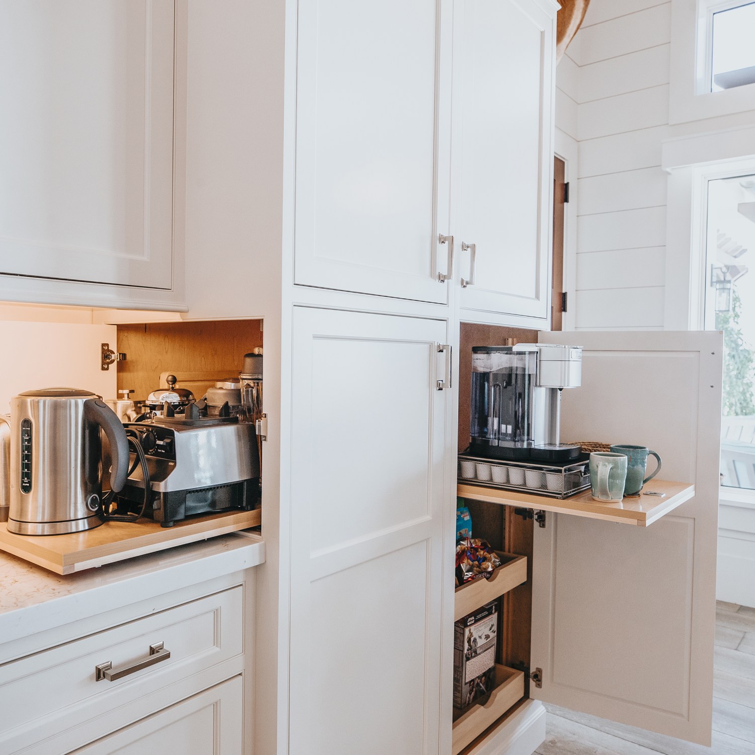 White kitchen with cabinet open to reveal hidden pull out