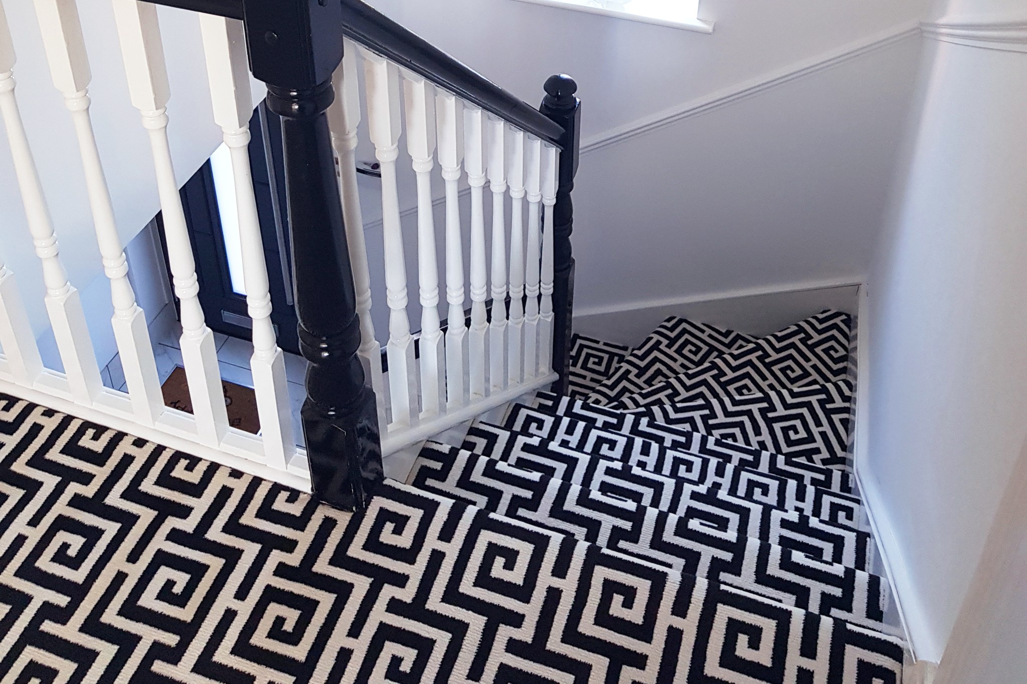 Spiral stairs covered in black and white geometric carpeting