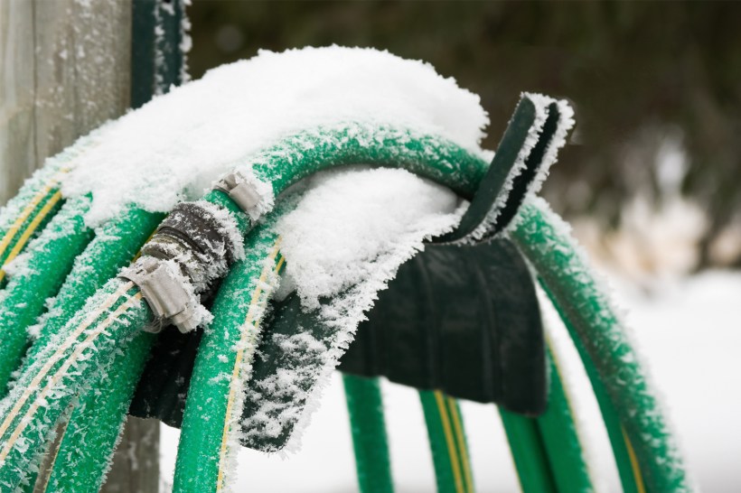 Frozen garden hose outside a house