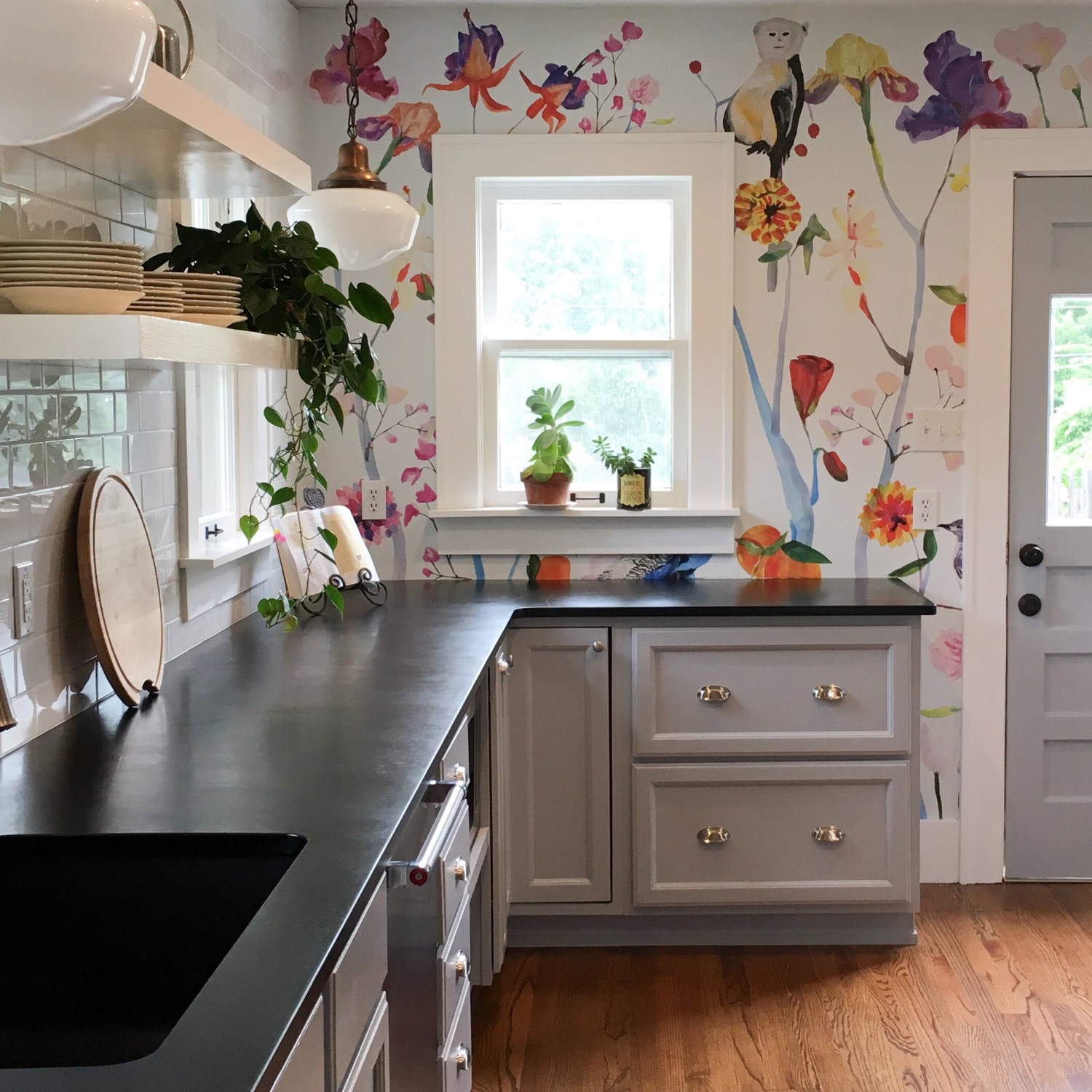 Gray kitchen counters against colorful floral wallpaper