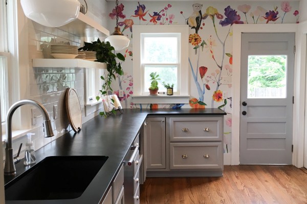 Gray kitchen counters against colorful floral wallpaper