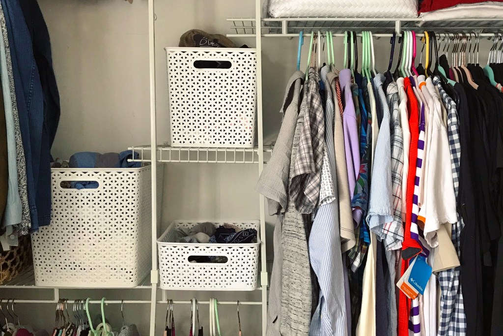 Closet system featuring shirts and four white baskets