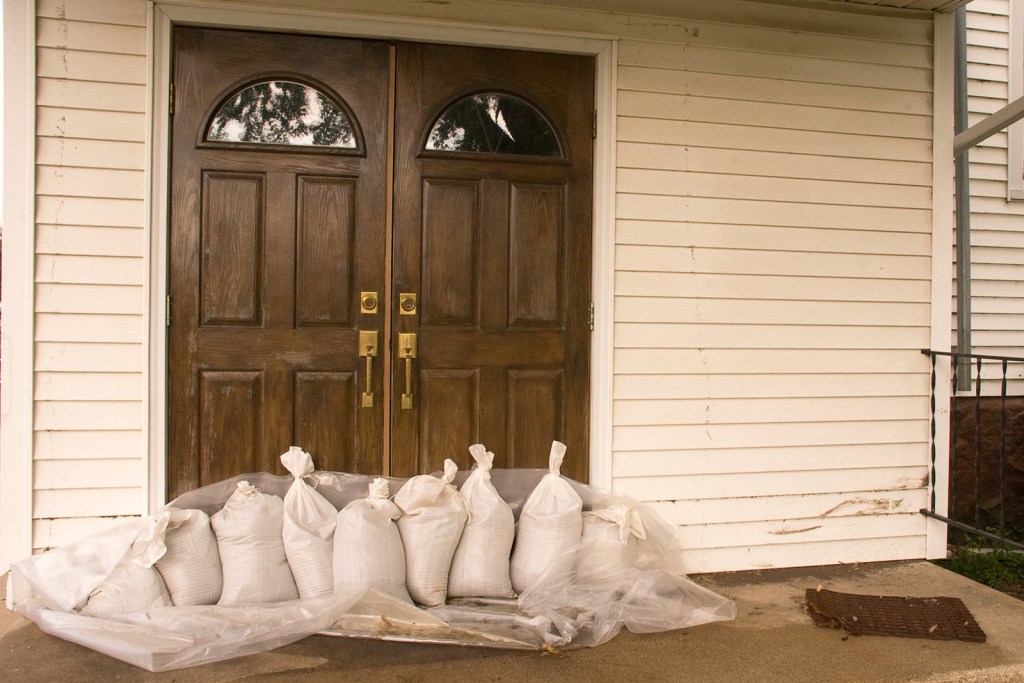 Sandbags piled next to front door of a home