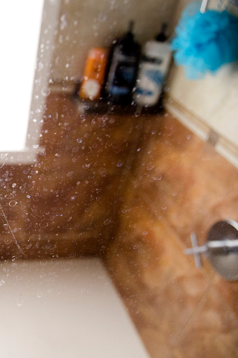 A glass shower door with soap scum