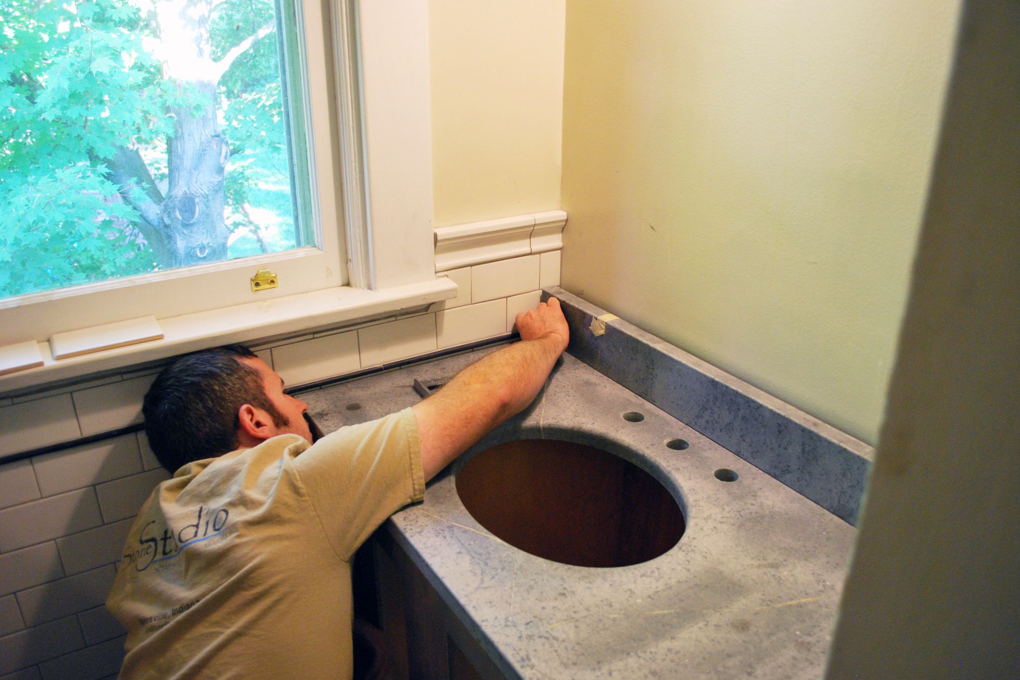 Man installing tile in a bathroom