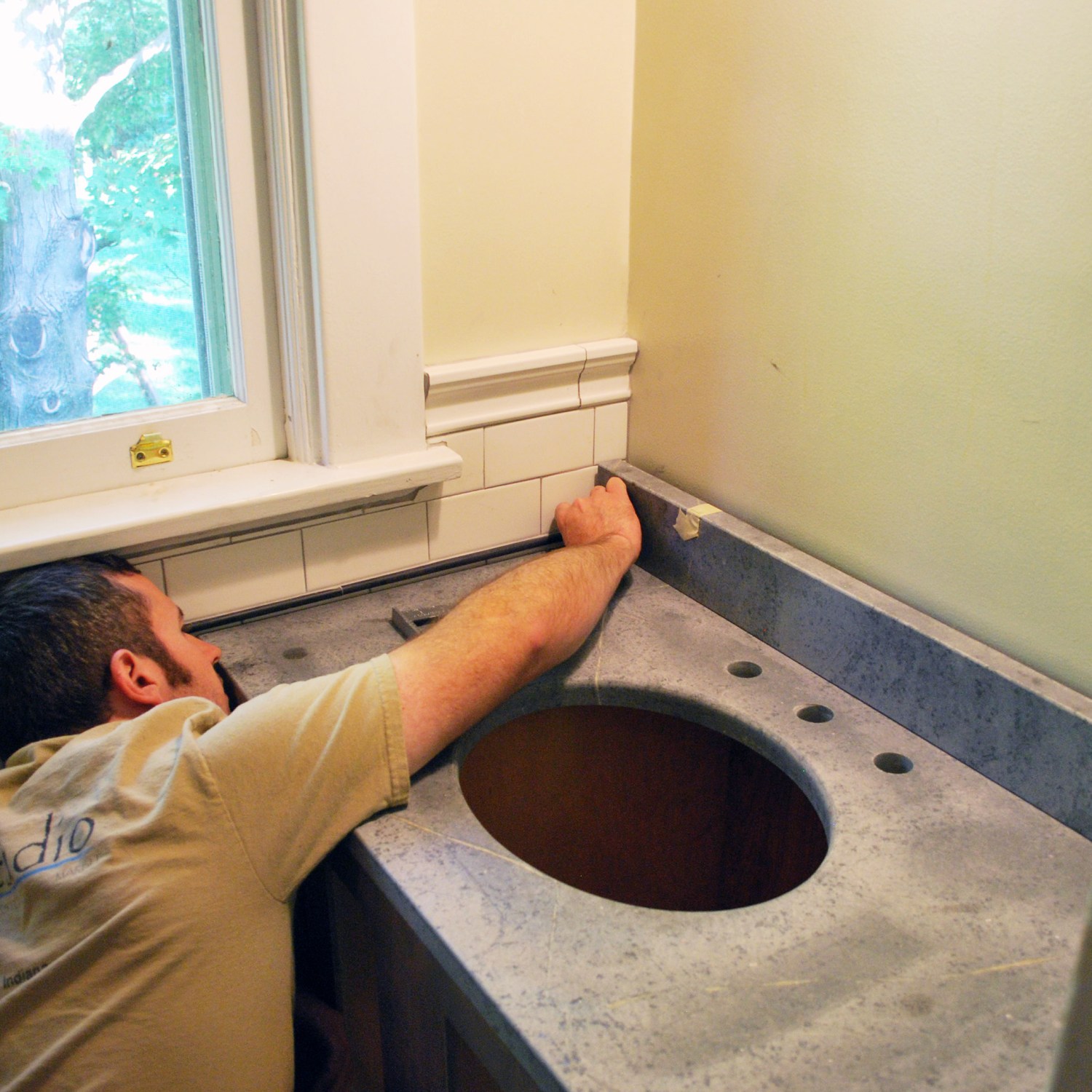 Man installing tile in a bathroom