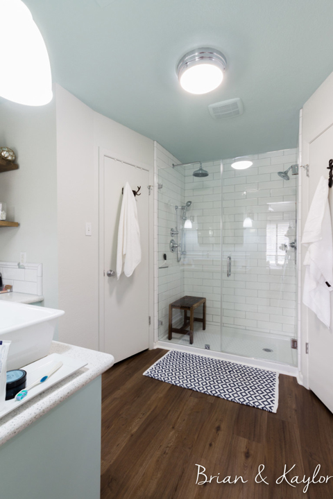 A bright white-walled bathroom with walk-in, tiled shower