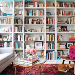 Built-in floor to ceiling bookshelves with grey couch and glass coffee table