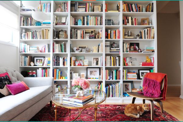 Built-in floor to ceiling bookshelves with grey couch and glass coffee table