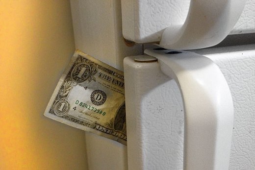 Dollar bill stuck in a refrigerator door