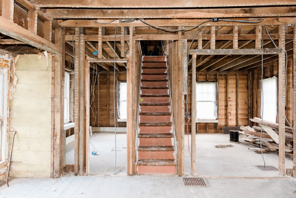 Brown stair case of home undergoing gut rehab