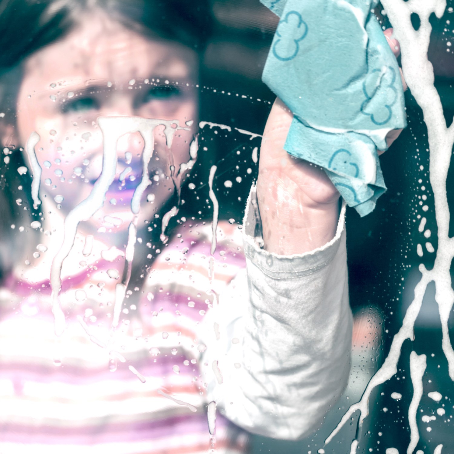 Girl cleaning a window at her home