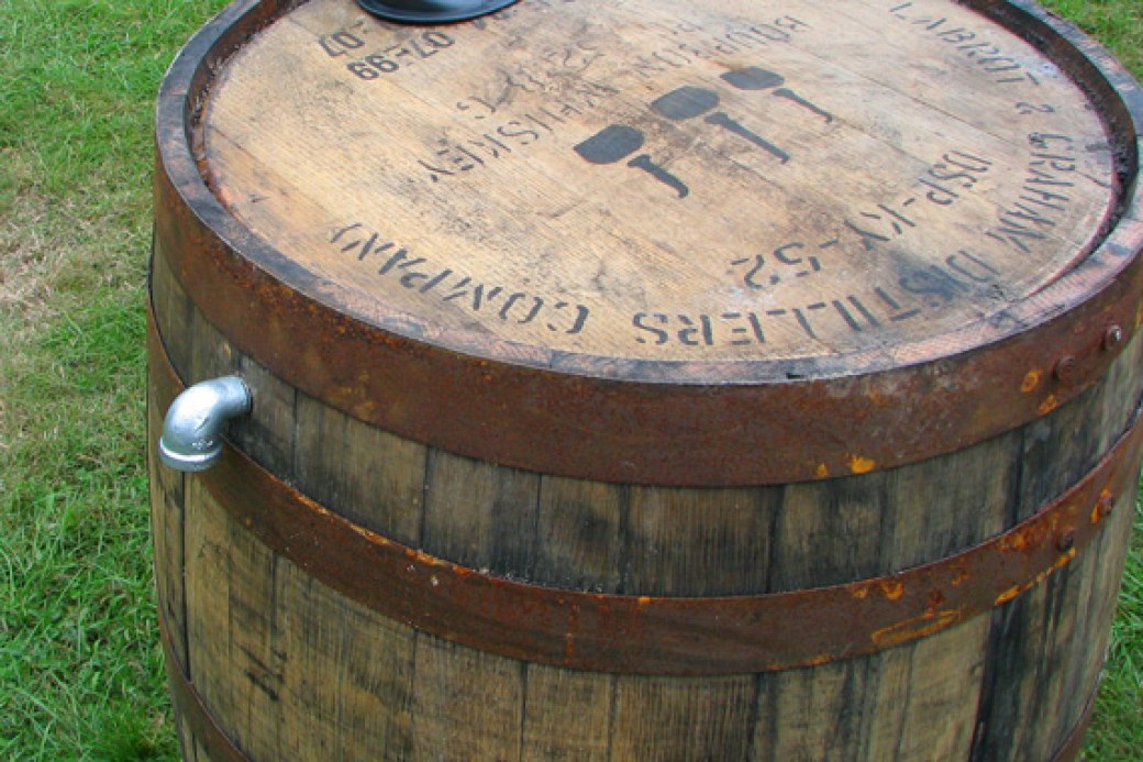 Wooden rain barrel repurposed from wine barrel