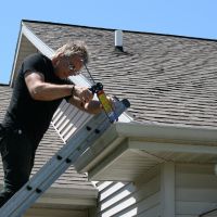 Gutter repair | Man fixing gutters on a house