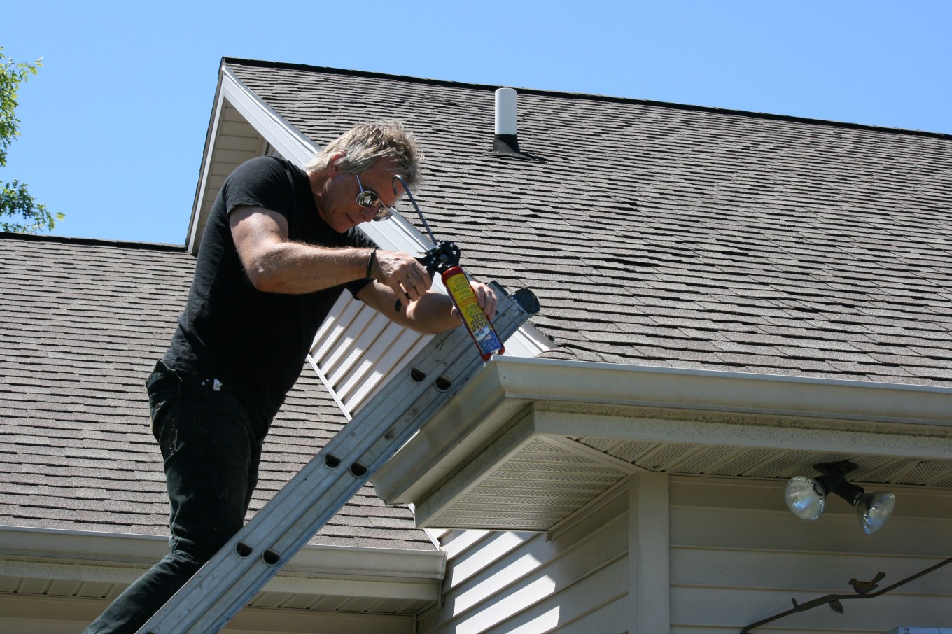 Gutter repair | Man fixing gutters on a house