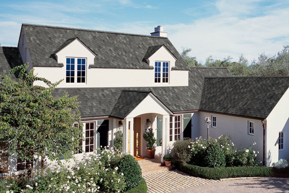 White home with grey architectural shingles. 