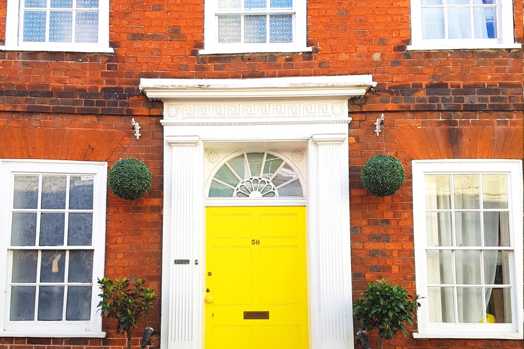 Red brick exterior with yellow front door and white trim