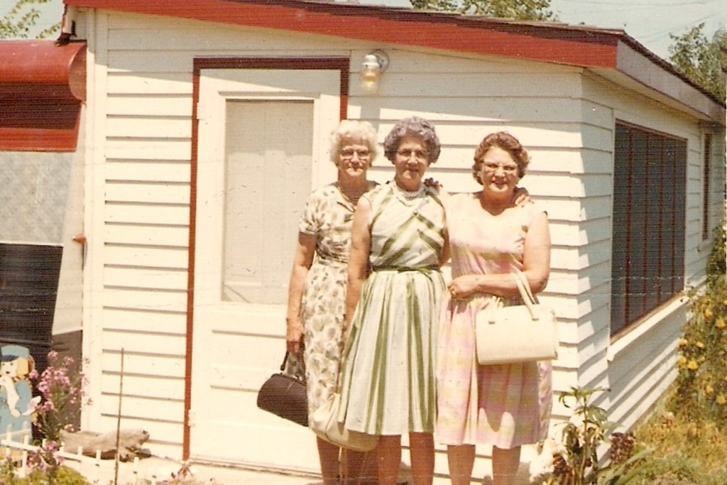 Three old ladies in front of a white building