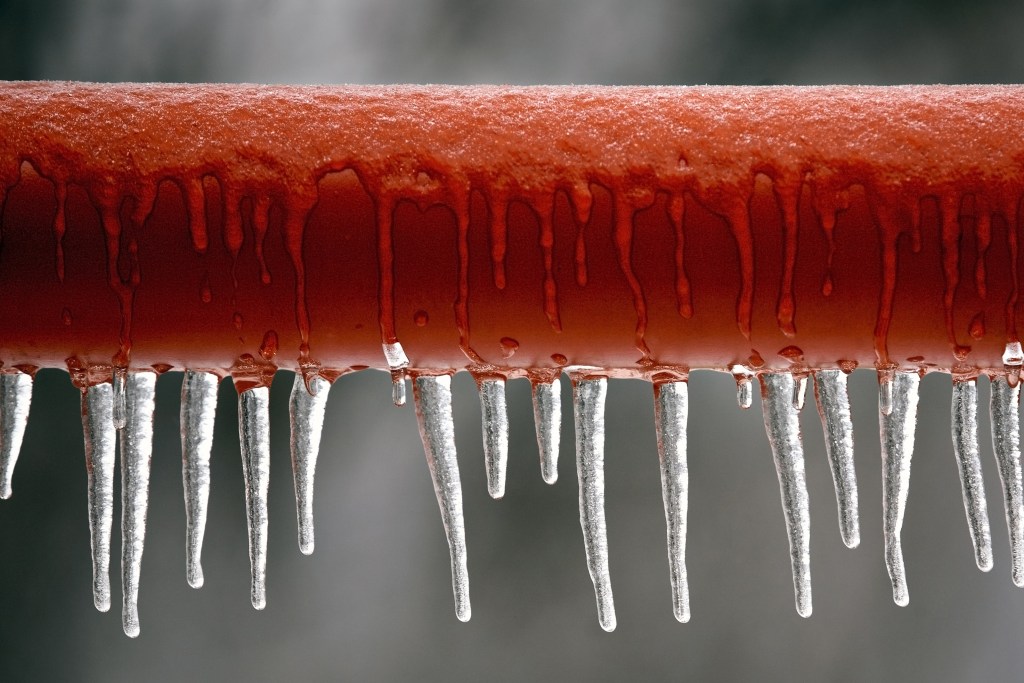 red frozen pipe with icicles in a home