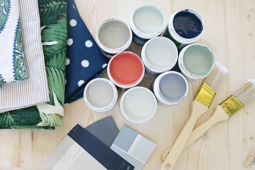 colorful fabric swatches sample paint cans and paintbrushes on wooden table ideas to create dream home