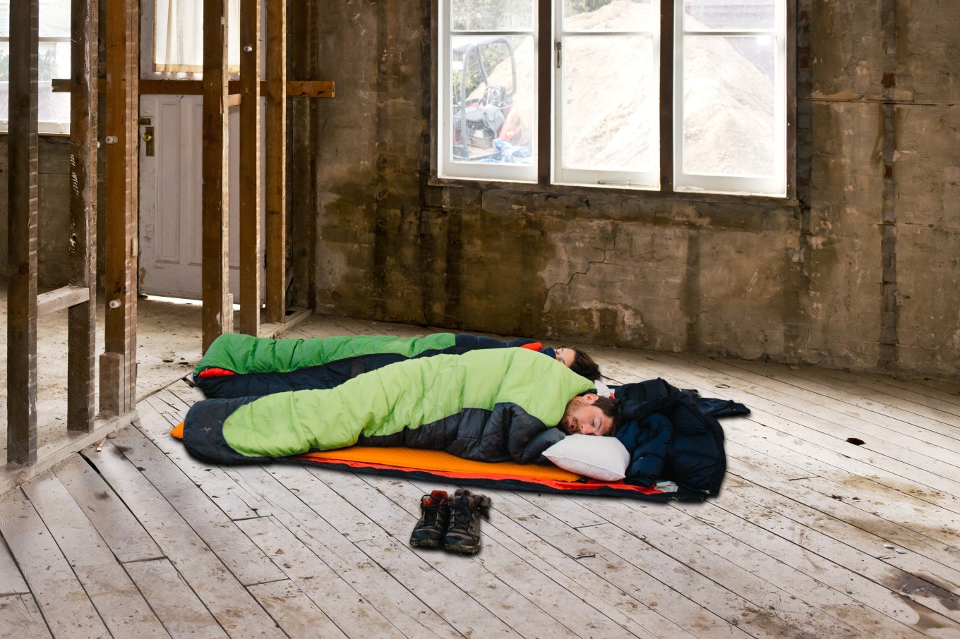 Couple in sleeping bags during home renovation