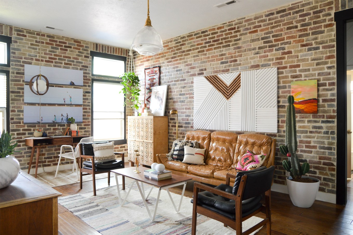 Bright living room with brick walls and wood floors