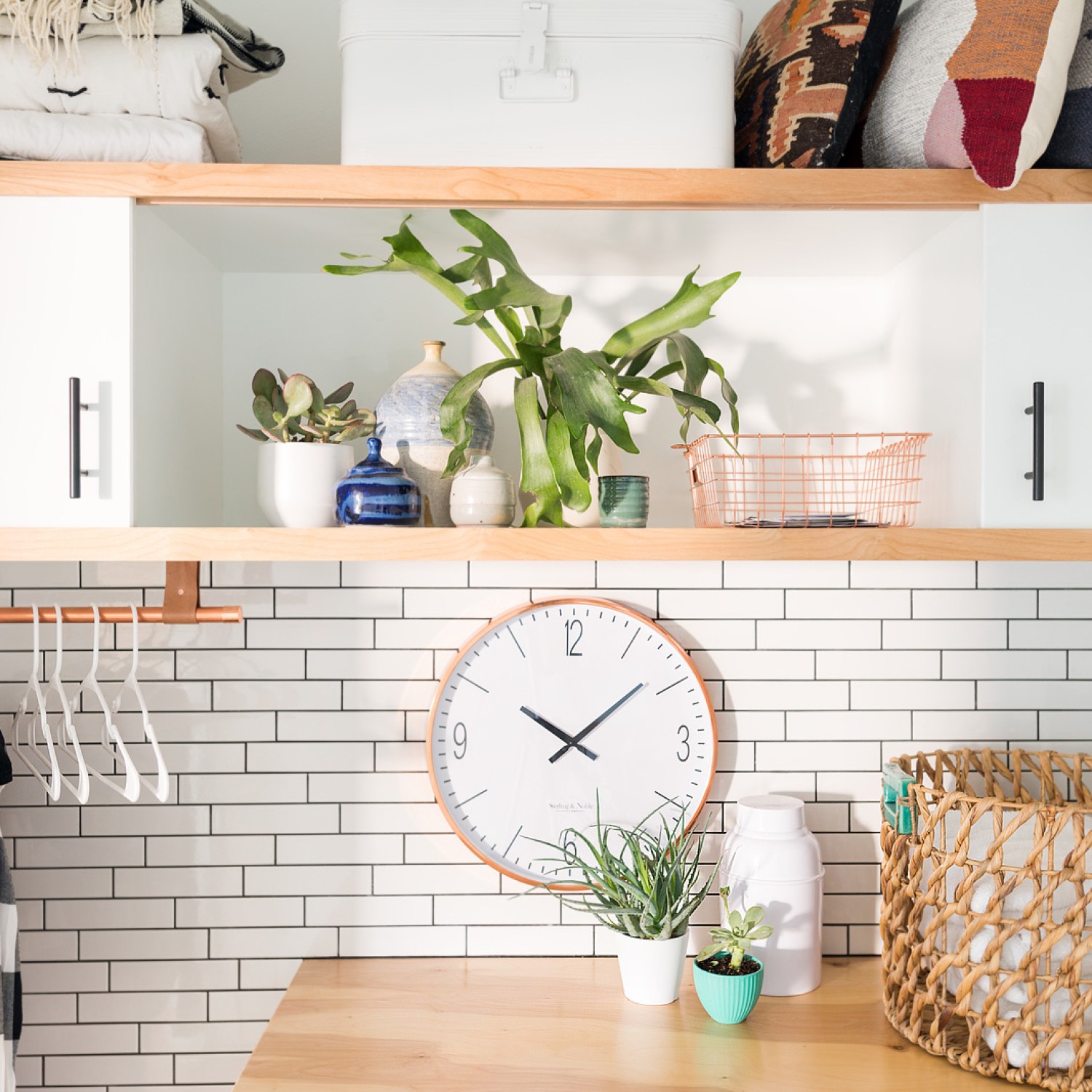 Updated laundry room with white subway tile and a clock