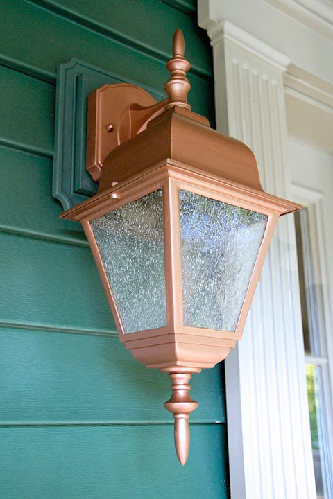 Green house siding with new copper painted porch light