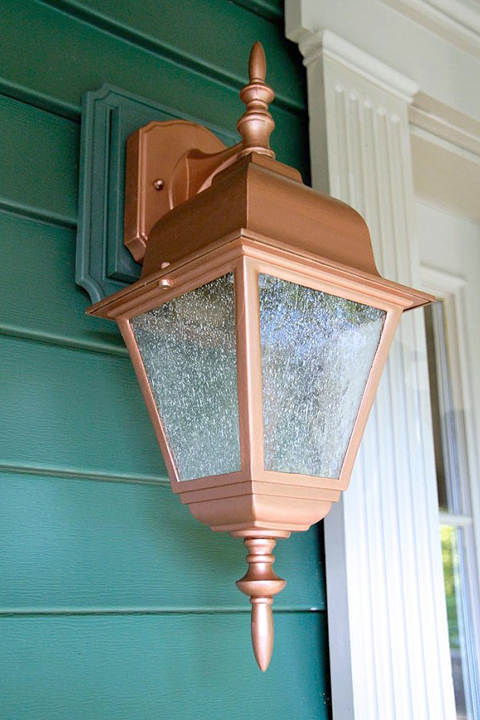 Green house siding with new copper painted porch light