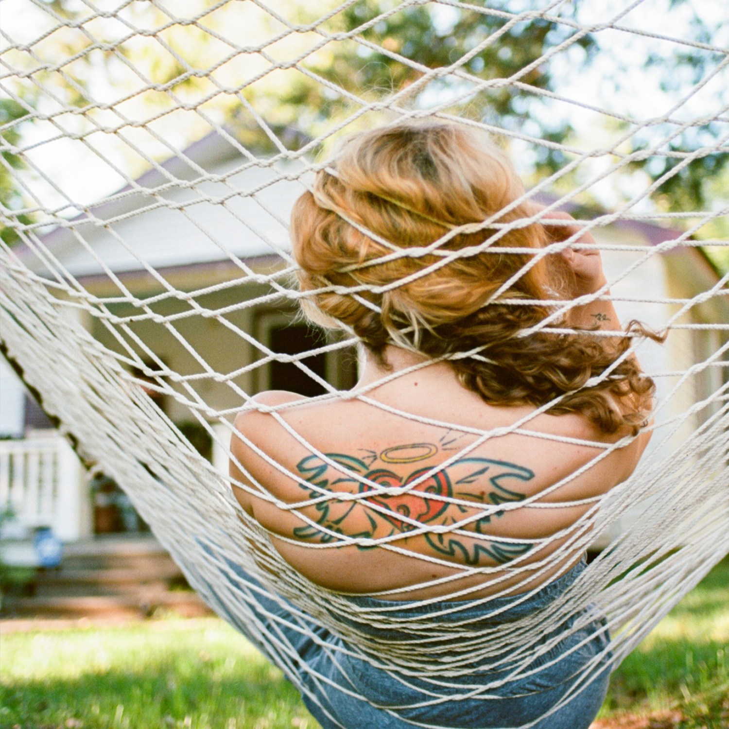 Woman with tattoo relaxing in hammock