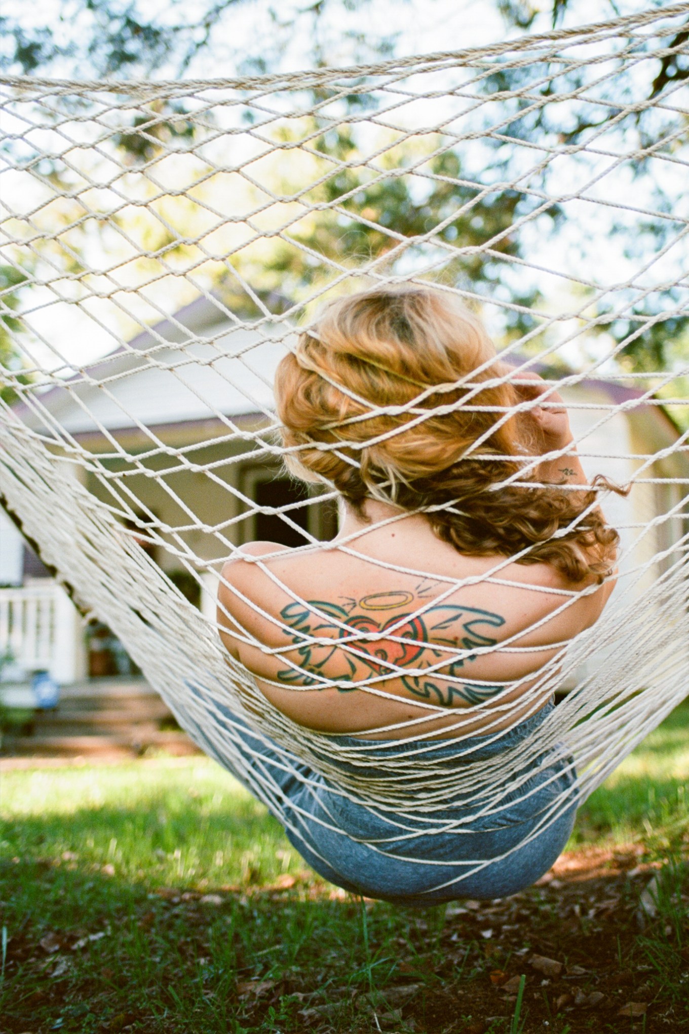 Woman with tattoo relaxing in hammock