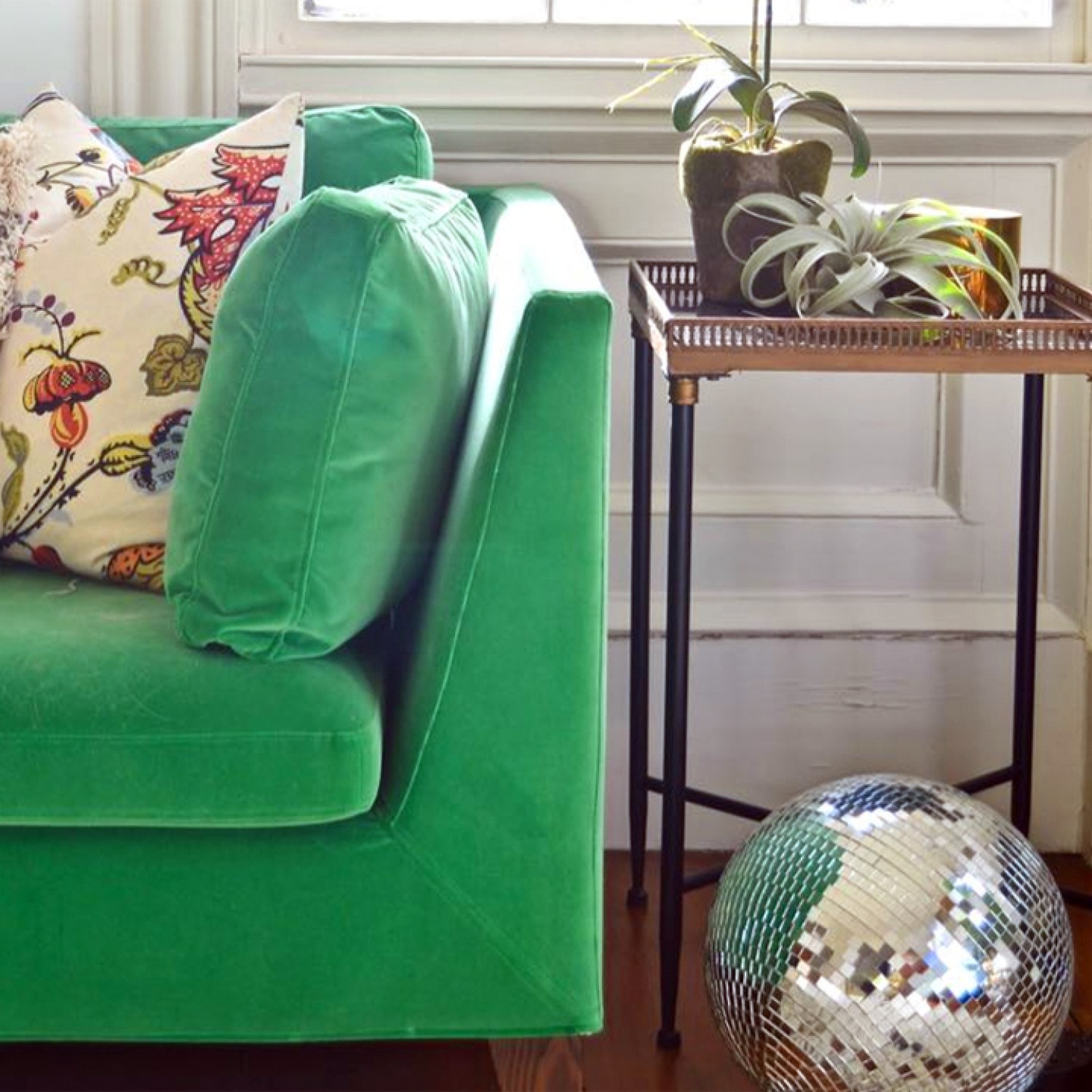 Green velvet couch in a home living room