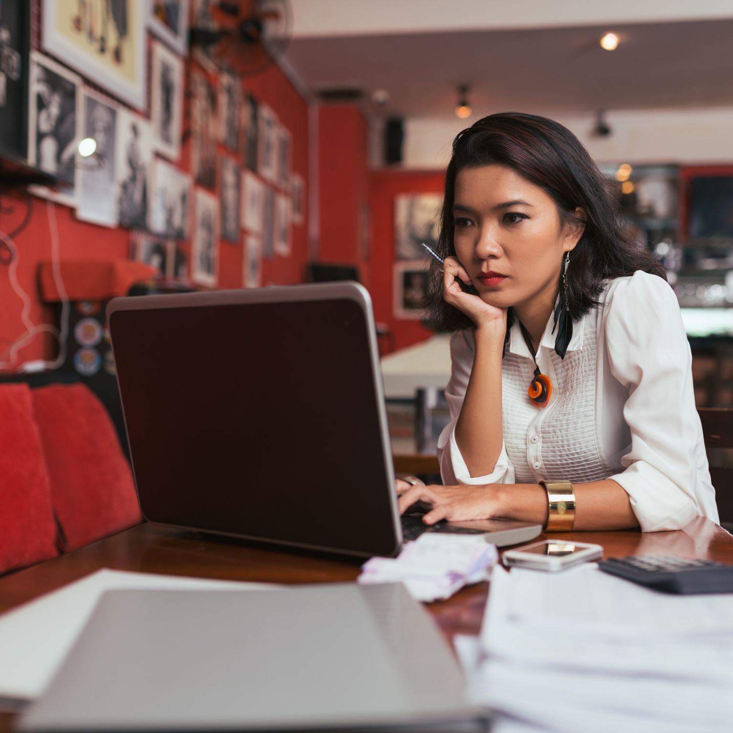 Woman staring at laptop computer at a table in a coffee shop