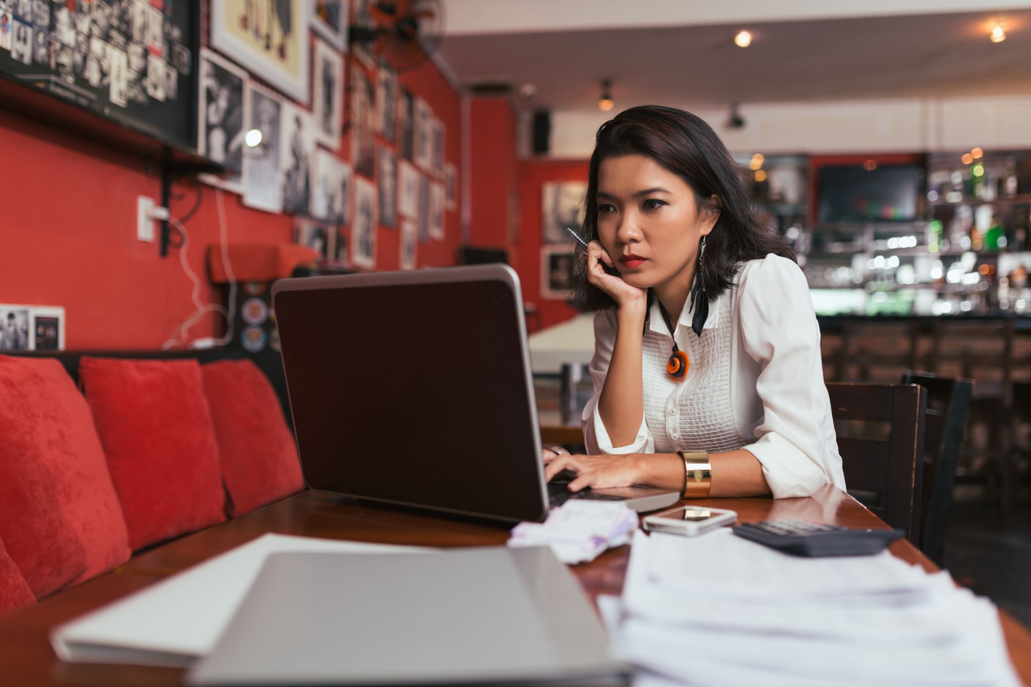 Woman staring at laptop computer at a table in a coffee shop