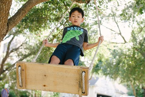 Boy on a rope swing outside