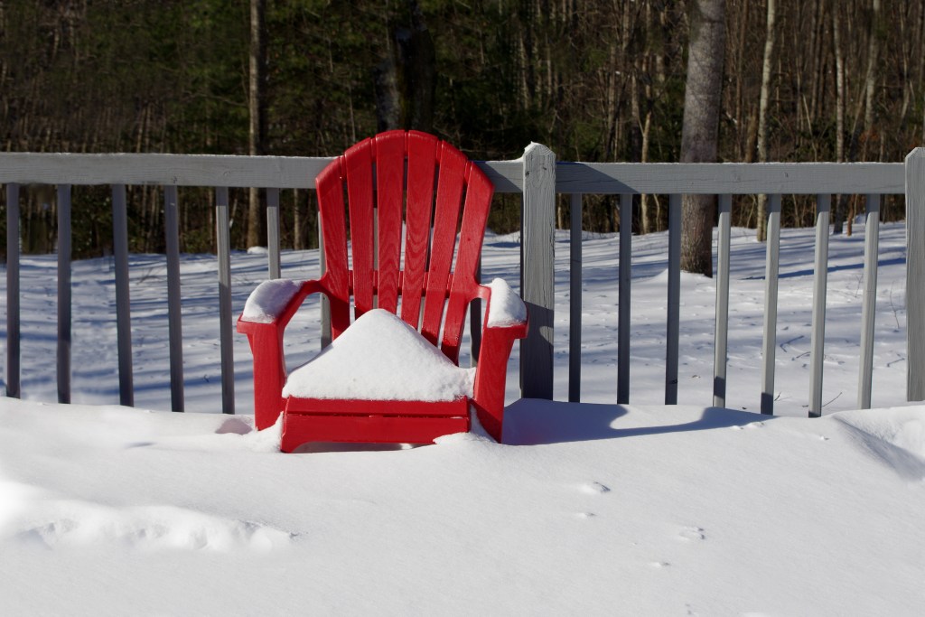 A red chair covered in snow