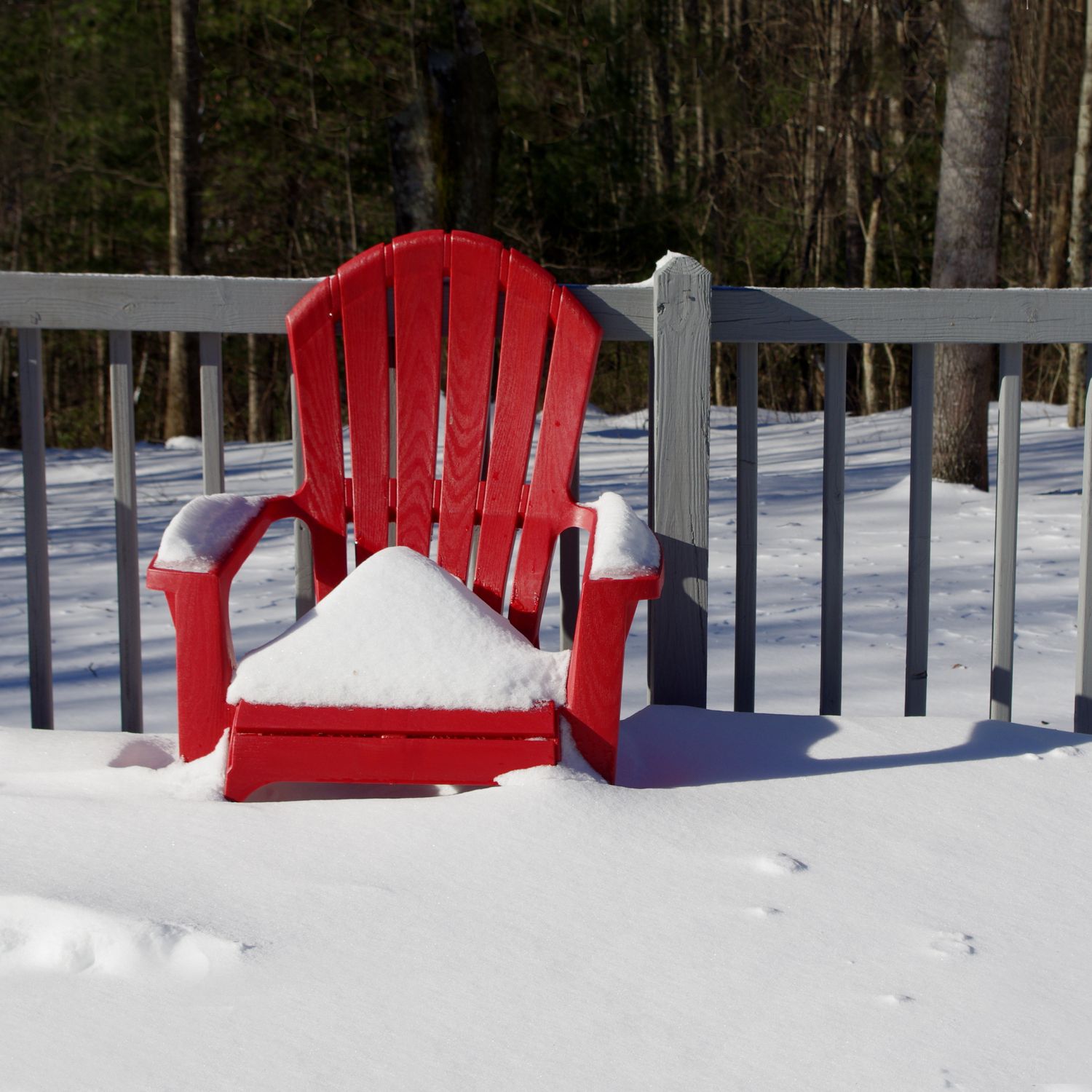 A red chair covered in snow