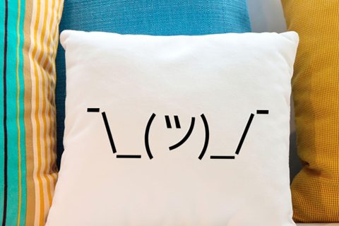 Shrugging emoji on a throw pillow