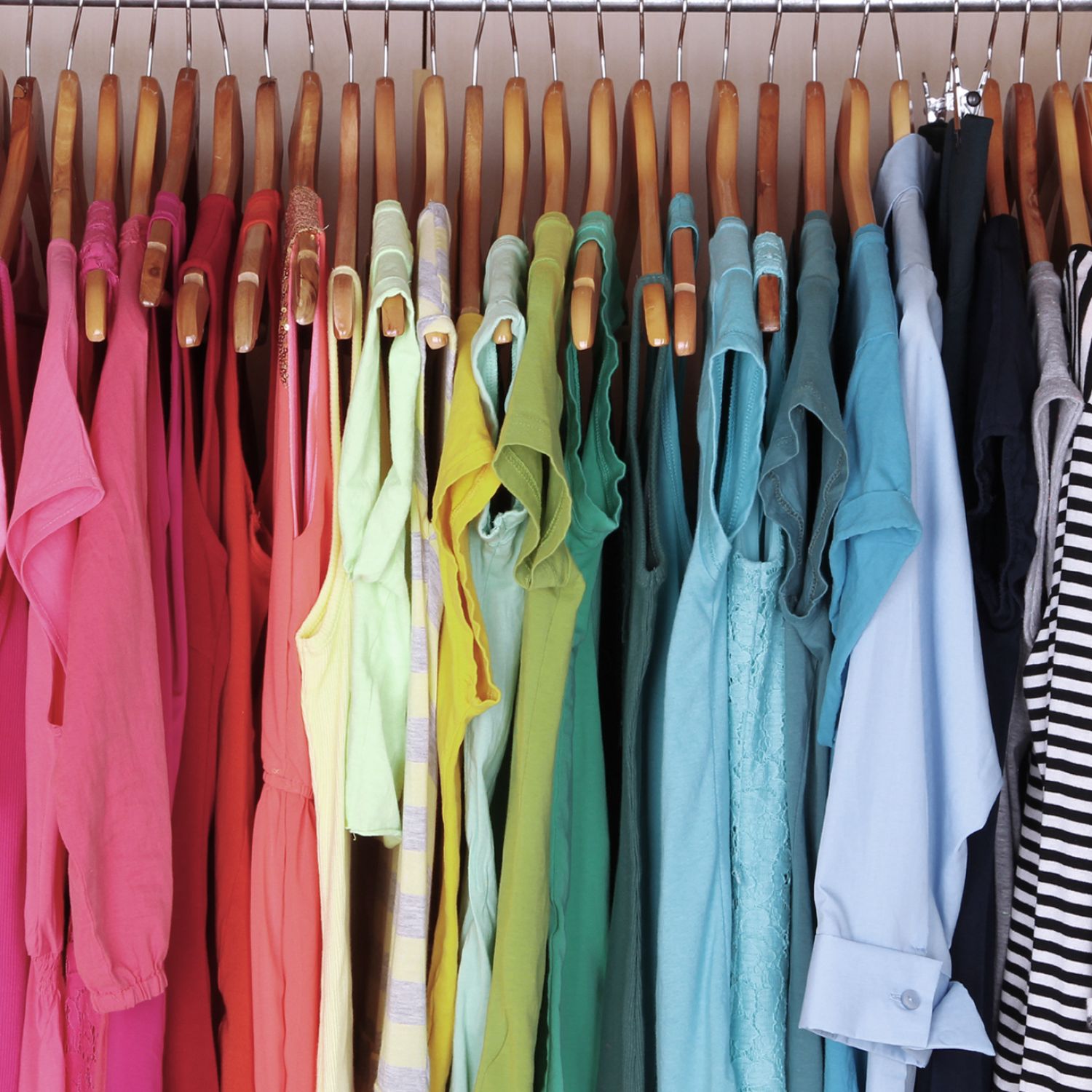 Rainbow organized clothes in a closet