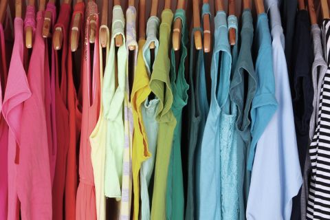 Rainbow organized clothes in a closet