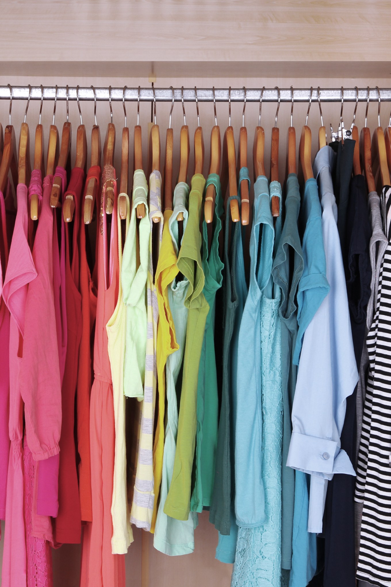 Rainbow organized clothes in a closet