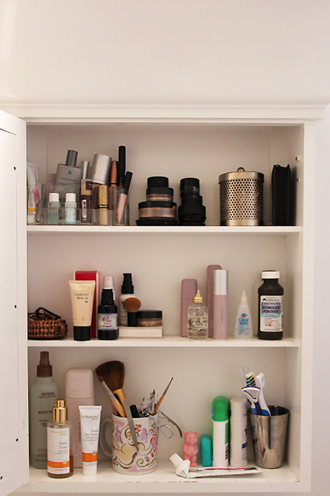 A dim medicine cabinet filled with toiletries