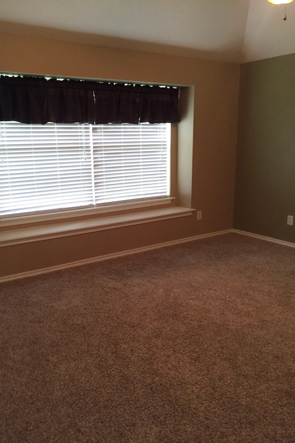 A before image of a dark carpeted bedroom