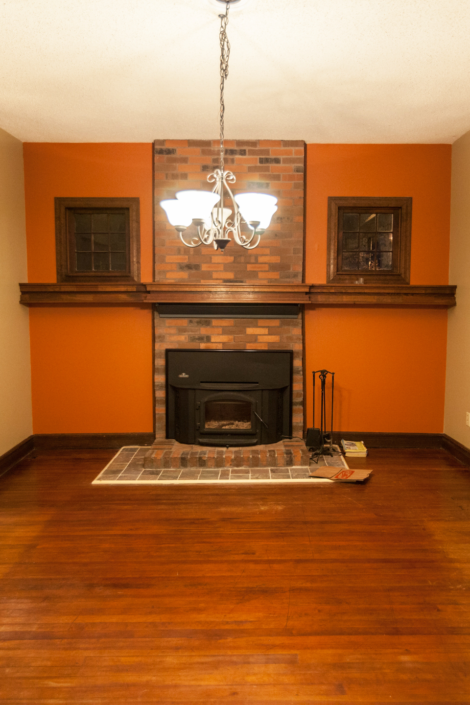 A before image of a living room with brick fireplace